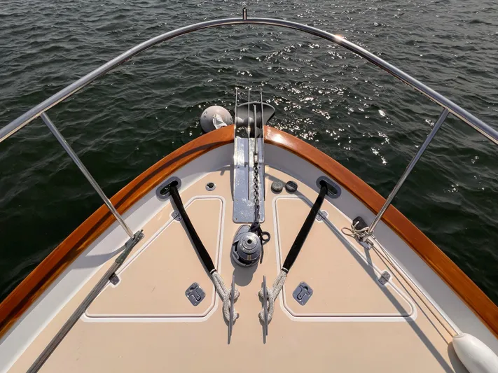 Indigo Yacht Photos Pics Bow of 2007 Bruckmann 34e boat with anchor and railing on calm water.