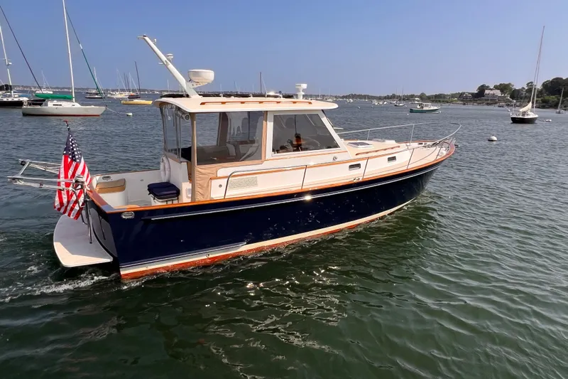 Indigo Yacht Photos Pics 2007 Bruckmann 34e boat cruising in a scenic harbor with American flag.