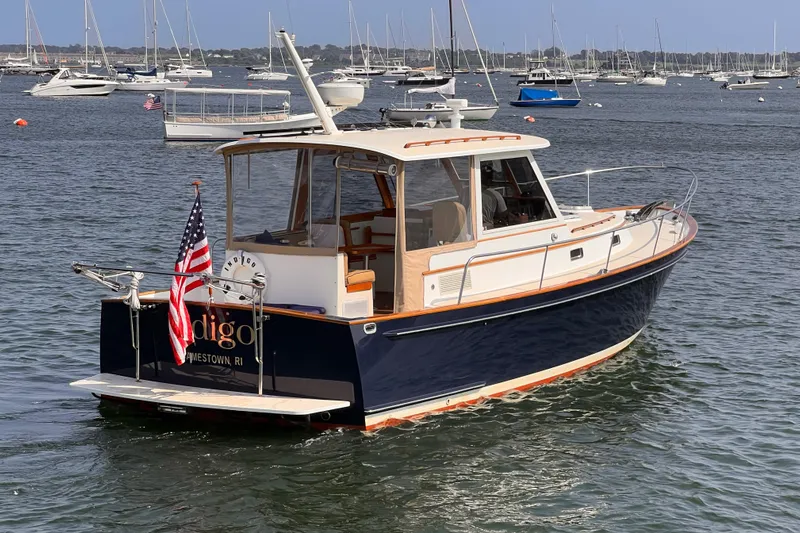 Indigo Yacht Photos Pics 2007 Bruckmann 34e boat on water, displaying American flag, surrounded by other boats.