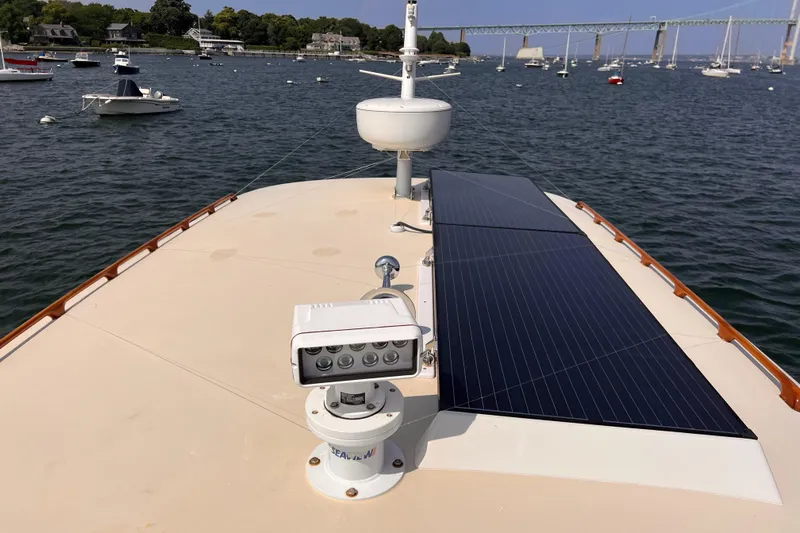 Indigo Yacht Photos Pics Bruckmann 34e 2007 boat with solar panels on deck, anchored in a scenic harbor.