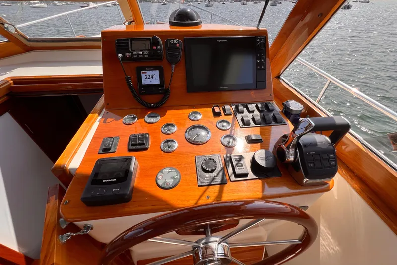 Indigo Yacht Photos Pics Bruckmann 34e 2007 boat helm with navigation controls and wooden steering wheel.
