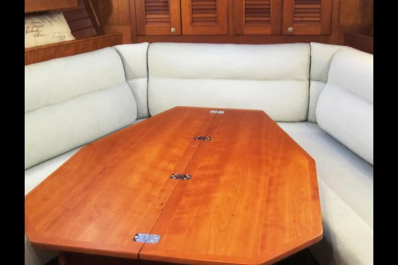 Dreamwalker Yacht Photos Pics Interior of 2008 Gozzard 41B yacht with wooden table and cushioned seating.