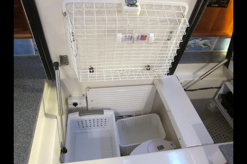 Dreamwalker Yacht Photos Pics Interior storage compartment of 2008 Gozzard 41B yacht with organized baskets and thermometer.