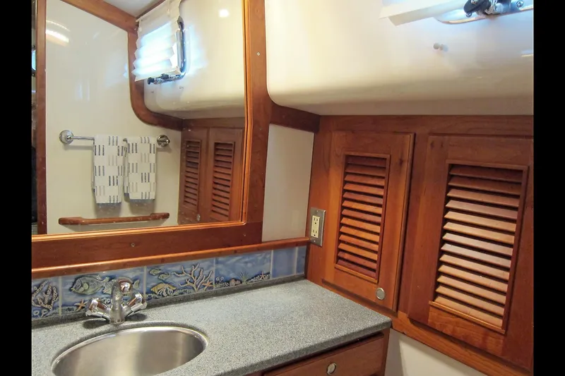 Dreamwalker Yacht Photos Pics Luxurious 2008 Gozzard 41B yacht bathroom with wooden cabinets and elegant fixtures.