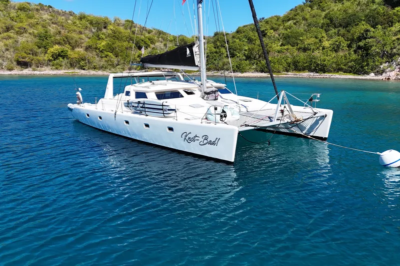 Knot Bad! Yacht Photos Pics 2008 Voyage Yachts 500 catamaran anchored in clear blue water near lush green shoreline.