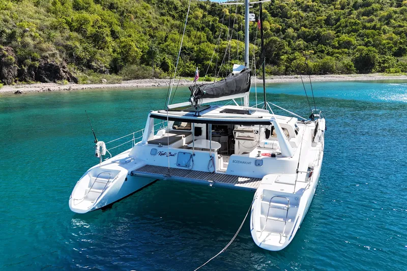 Knot Bad! Yacht Photos Pics 2008 Voyage Yachts 500 catamaran anchored in clear turquoise waters near a lush green shoreline.