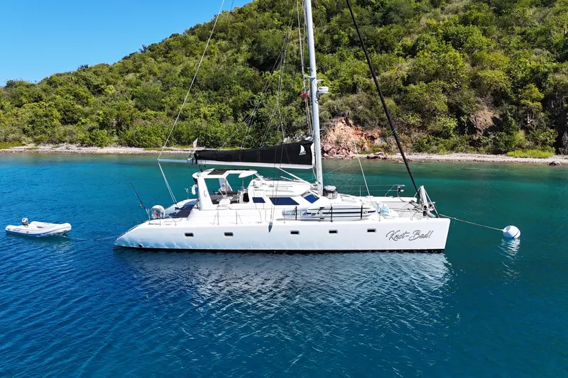 Knot Bad! Yacht Photos Pics 2008 Voyage Yachts 500 catamaran anchored in clear blue water near lush green shoreline.