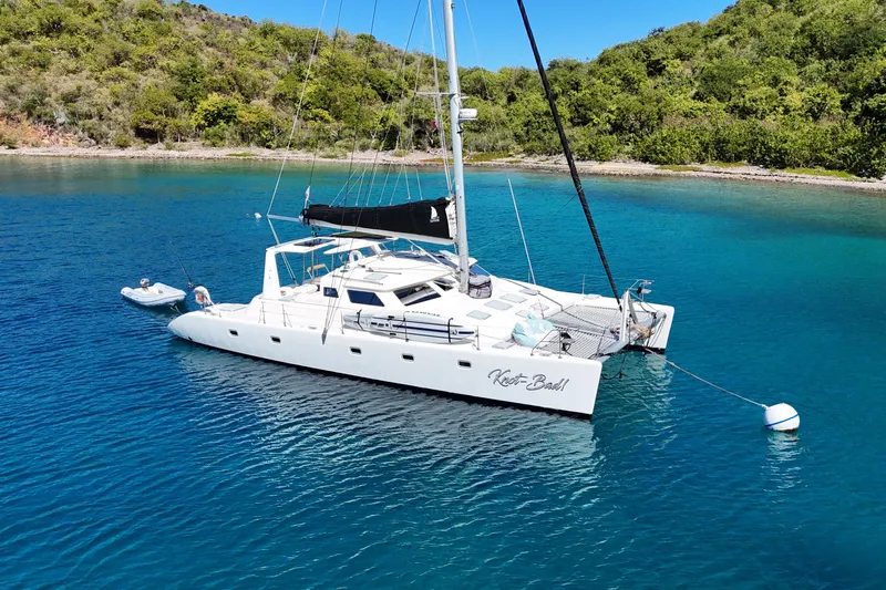 Knot Bad! Yacht Photos Pics 2008 Voyage Yachts 500 catamaran anchored in clear blue water near lush green shoreline.