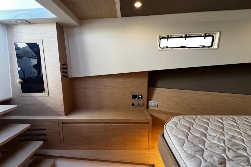 Esimar Yacht Photos Pics Luxurious interior of 2023 Solaris Power 40 Open yacht with modern wood finish and cozy bed.