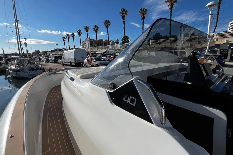 Esimar Yacht Photos Pics 2023 Solaris Power 40 Open yacht docked at marina with palm trees and blue sky.