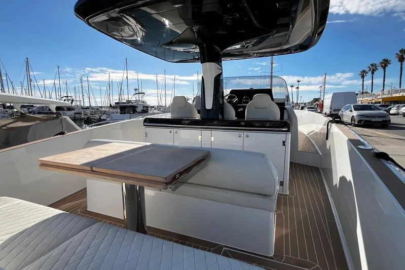 Esimar Yacht Photos Pics 2023 Solaris Power 40 Open yacht interior with seating and table, docked at marina.