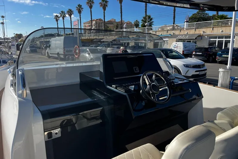 Esimar Yacht Photos Pics 2023 Solaris Power 40 Open yacht dashboard with steering wheel and controls, docked at marina.