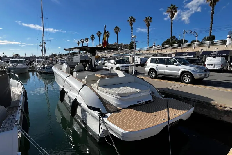 Esimar Yacht Photos Pics 2023 Solaris Power 40 Open yacht docked in a sunny marina with palm trees.