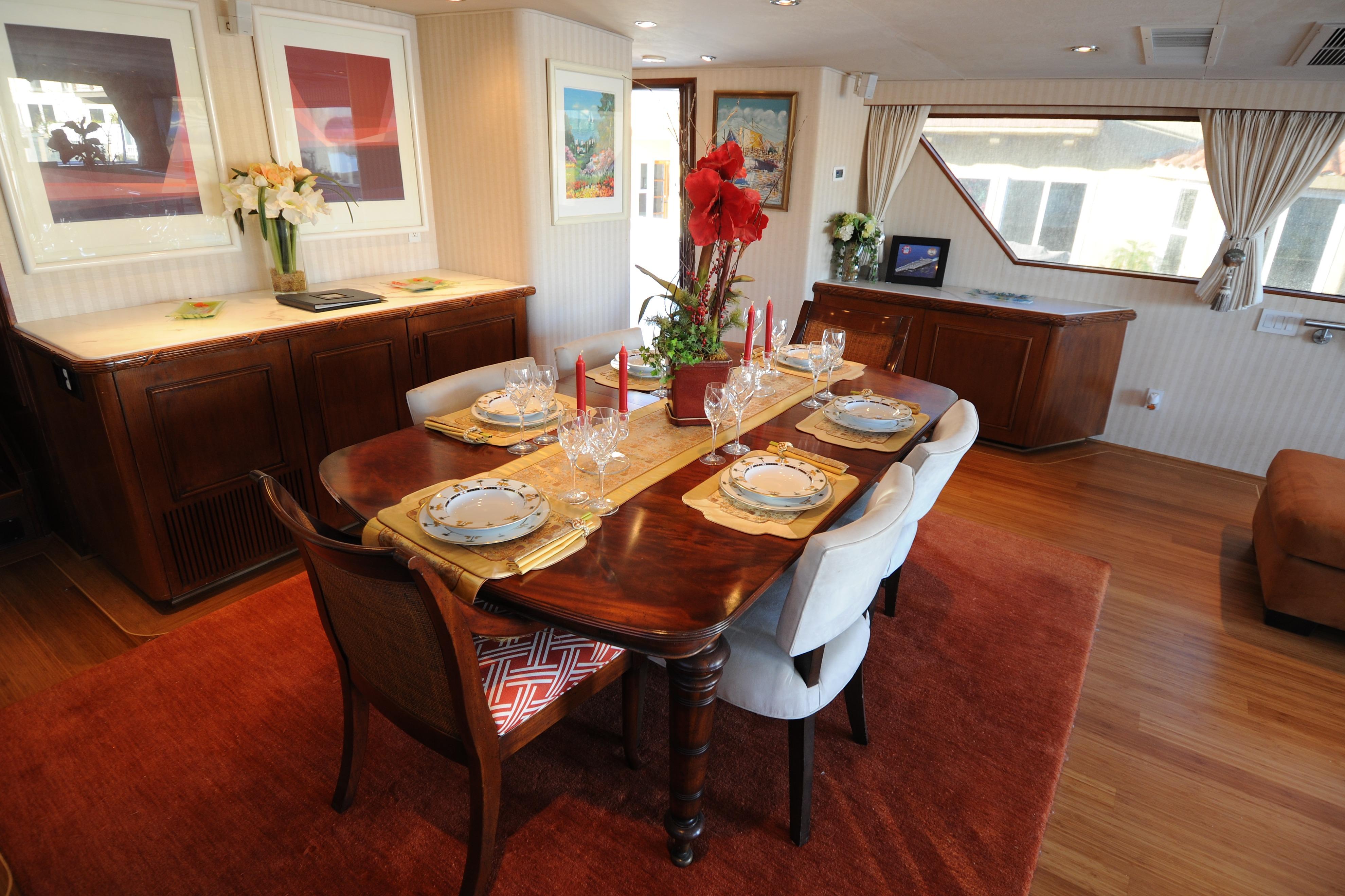 Luxurious dining area inside a 1987 Broward Cockpit Motor Yacht, featuring elegant table settings.