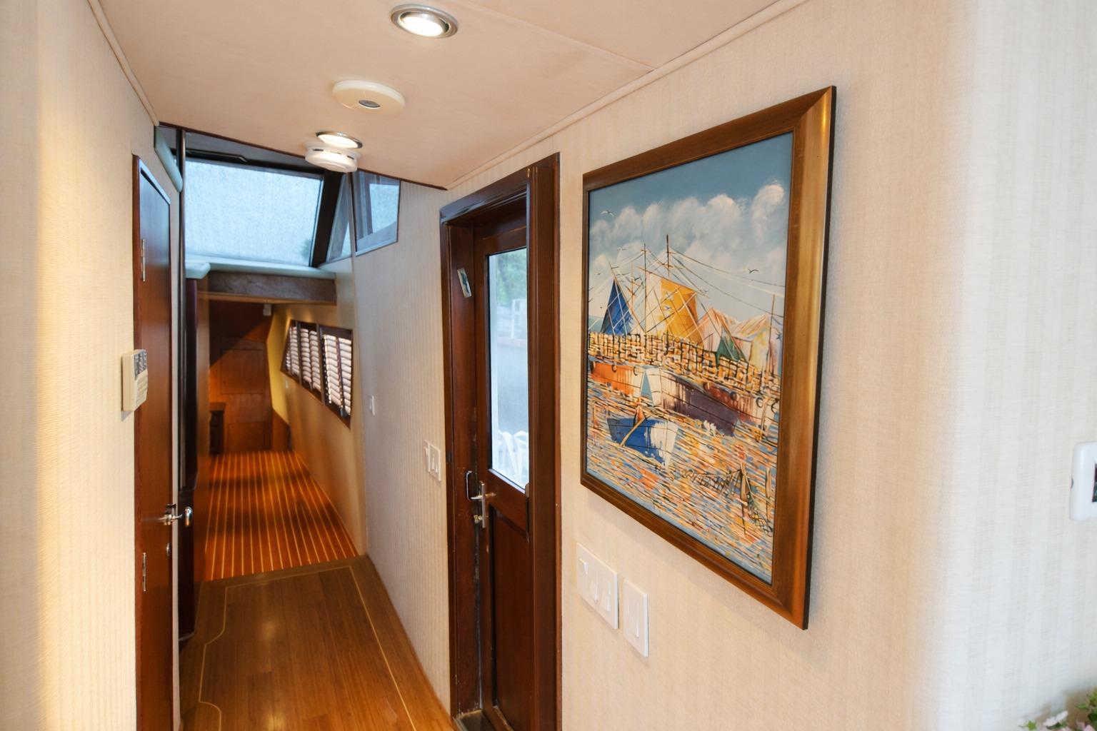 Hallway of 1987 Broward Cockpit Motor Yacht with nautical painting and wood accents.
