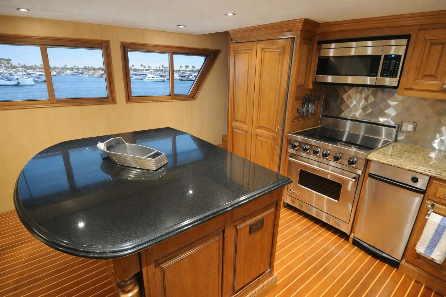 Luxurious kitchen interior of 1987 Broward Cockpit Motor Yacht with modern appliances and wood finishes.