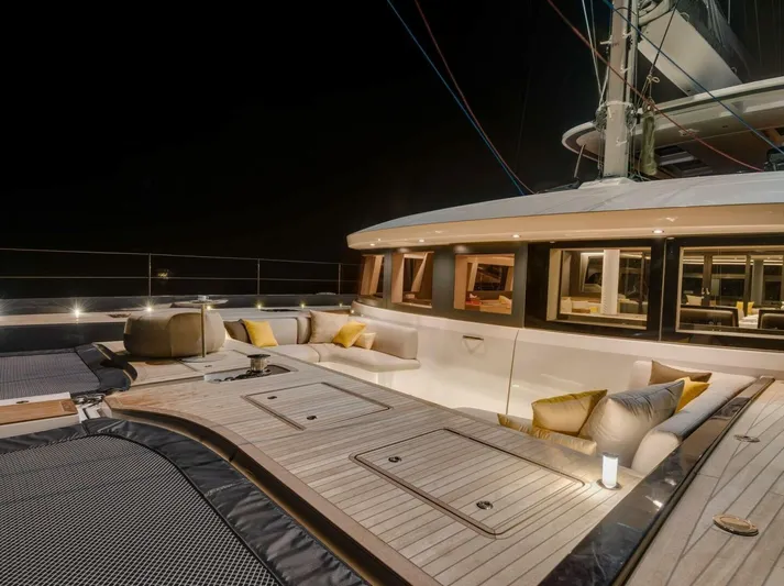 Sicilian Breeze Yacht Photos Pics Luxurious 2021 Lagoon Seventy 7 yacht deck at night, featuring elegant seating and ambient lighting.