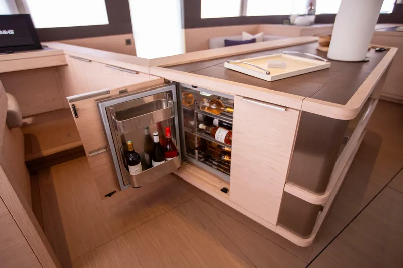 Sicilian Breeze Yacht Photos Pics Luxury yacht Lagoon Seventy 7 interior with open wine fridge, showcasing modern design.