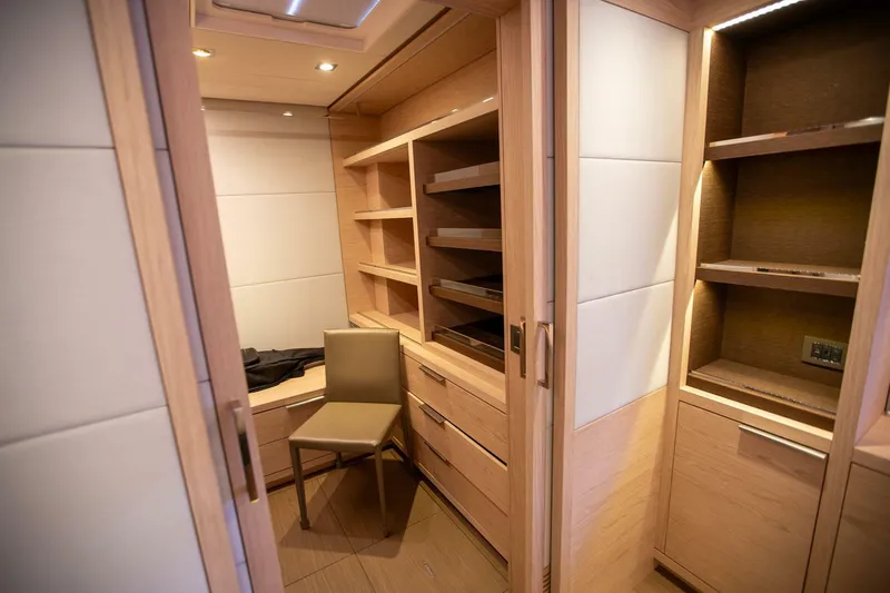 Sicilian Breeze Yacht Photos Pics Luxurious wooden interior of 2021 Lagoon Seventy 7 yacht with shelves and chair.