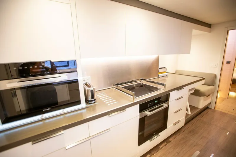 Sicilian Breeze Yacht Photos Pics Modern kitchen interior in 2021 Lagoon Seventy 7 yacht with sleek appliances and seating area.