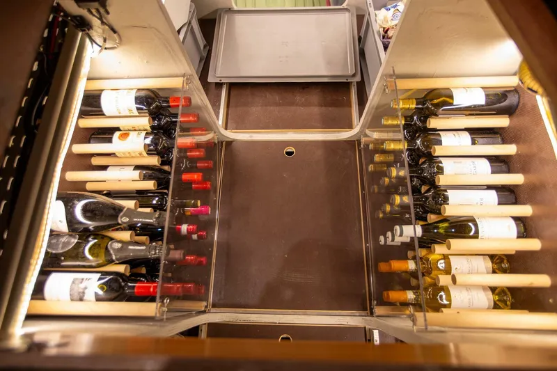 Sicilian Breeze Yacht Photos Pics Wine storage area in a 2021 Lagoon Seventy 7 yacht, featuring organized wine bottles.