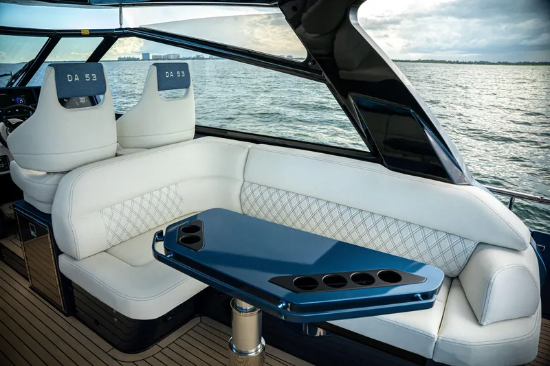  Yacht Photos Pics Luxurious 2025 Dutch American DA 53 yacht interior with white seating and sleek blue table.