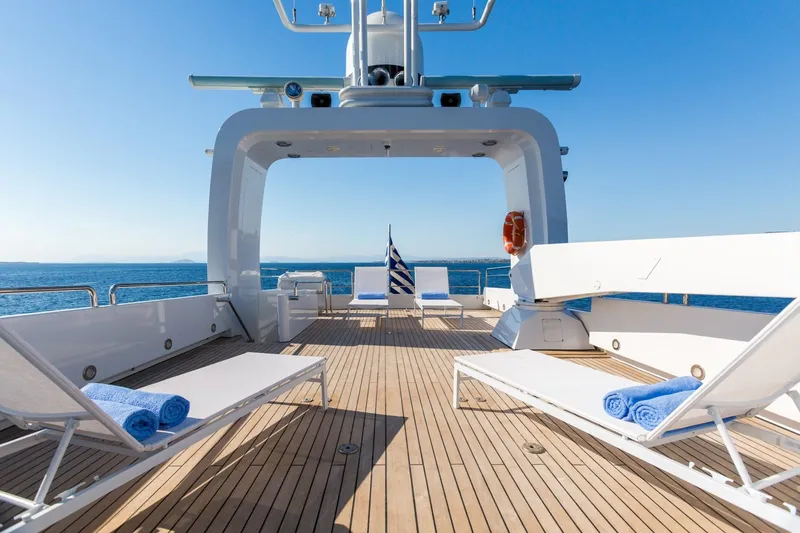 Aquarella Yacht Photos Pics Luxurious Devonport yacht deck with sun loungers, ocean view, and clear blue sky.
