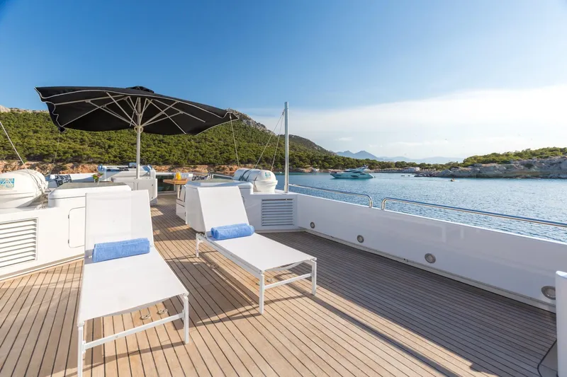 Aquarella Yacht Photos Pics Luxurious Devonport  yacht deck with sun loungers and umbrella, scenic ocean view.