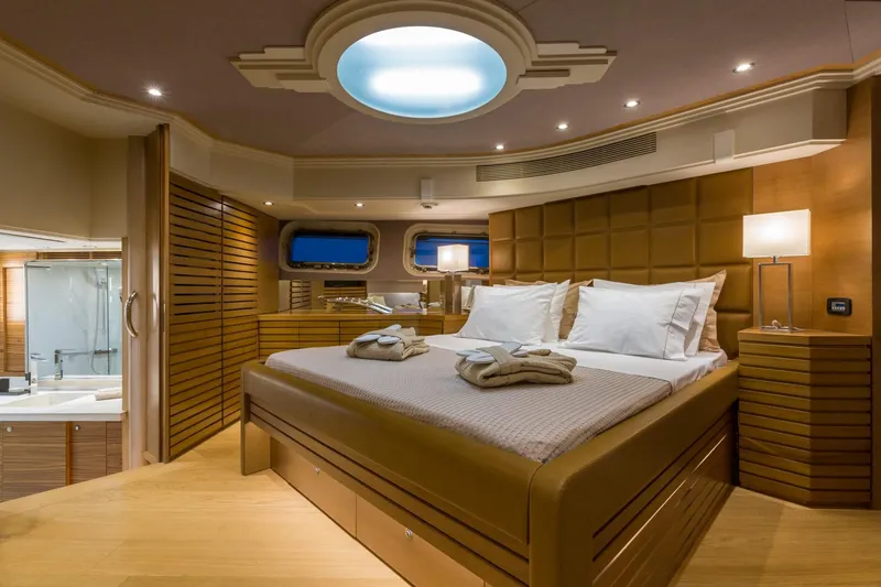 Aquarella Yacht Photos Pics Luxurious bedroom interior on Devonport yacht, 1994 model, featuring elegant wood paneling and ambient lighting.