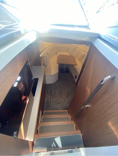  Yacht Photos Pics Interior view of 2021 Jeanneau Leader 12.5 WA yacht, featuring wooden stairs and modern design.