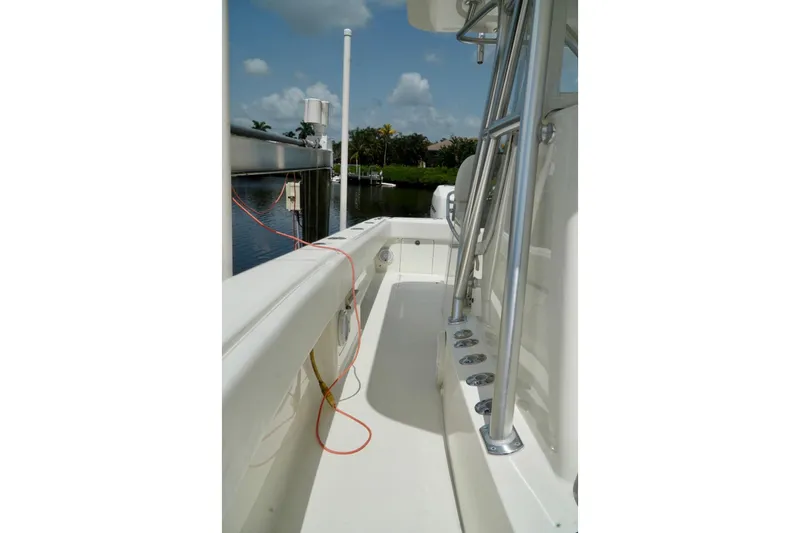  Yacht Photos Pics 2017 SeaVee 34Z boat deck with rod holders, docked by a calm waterway.