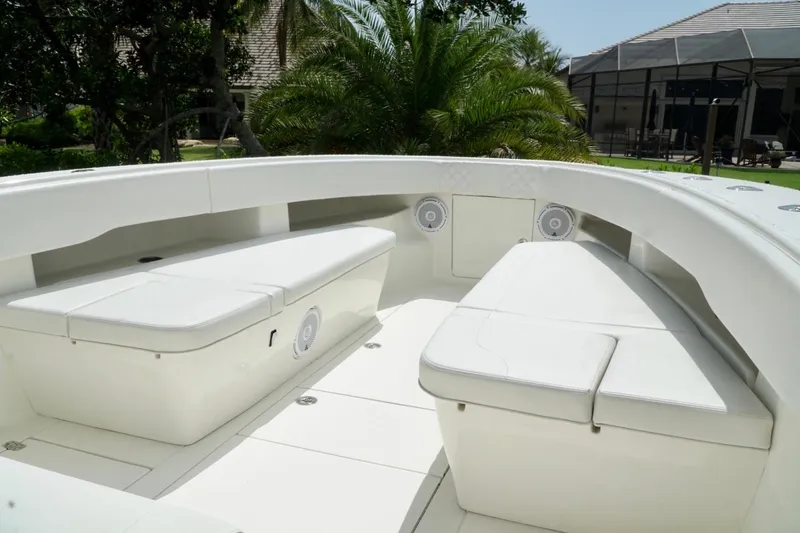  Yacht Photos Pics 2017 SeaVee 34Z boat interior with white seating and speakers, surrounded by lush greenery.