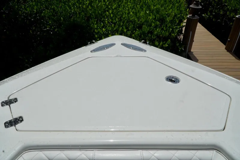  Yacht Photos Pics 2017 SeaVee 34Z boat deck with storage hatch, surrounded by lush greenery.