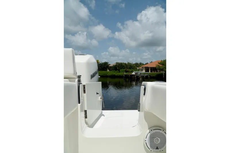  Yacht Photos Pics 2017 SeaVee 34Z boat with open door, overlooking serene waterfront and house.