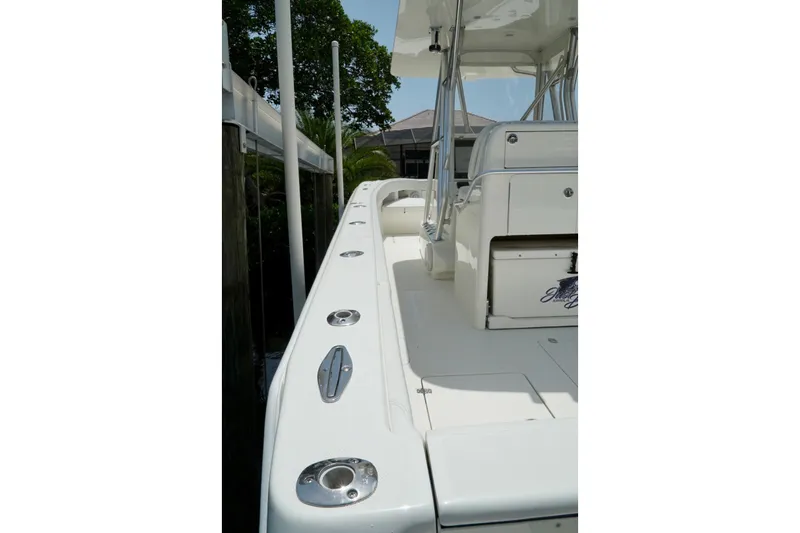  Yacht Photos Pics 2017 SeaVee 34Z boat deck with seating and rod holders, docked near greenery.