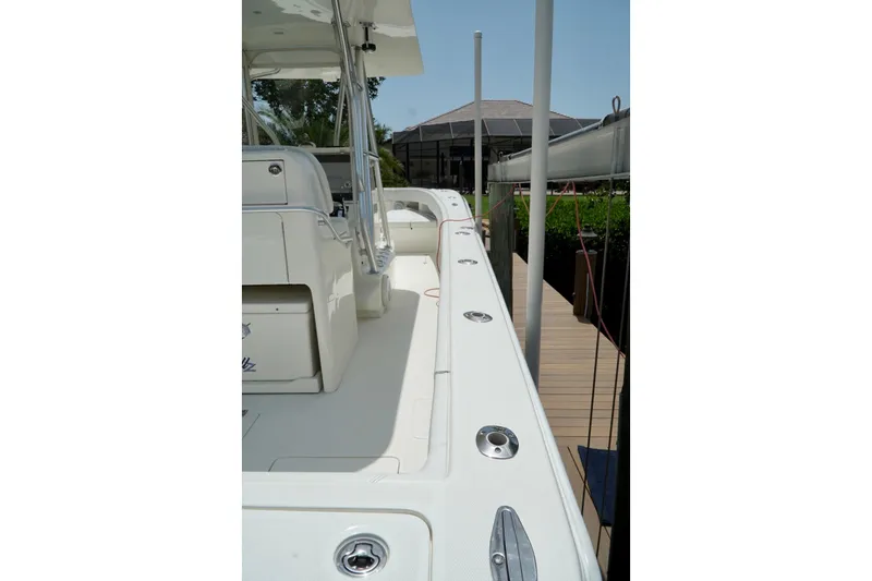  Yacht Photos Pics 2017 SeaVee 34Z boat deck with seating and rod holders, docked near a house.