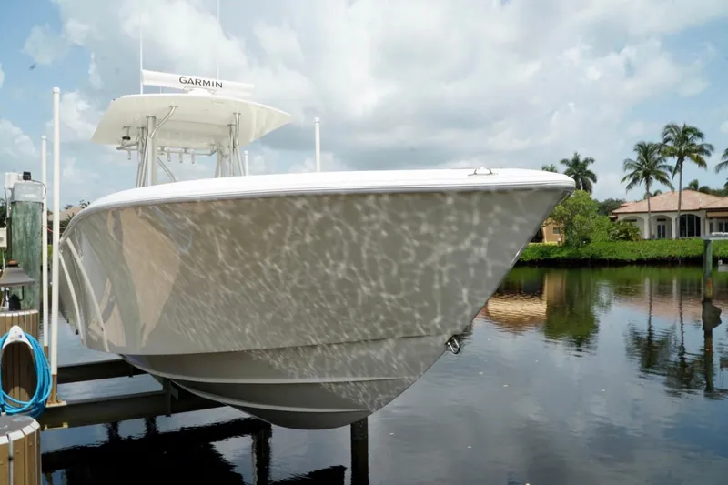  Yacht Photos Pics 2017 SeaVee 34Z boat docked by waterfront homes, reflecting on calm water.