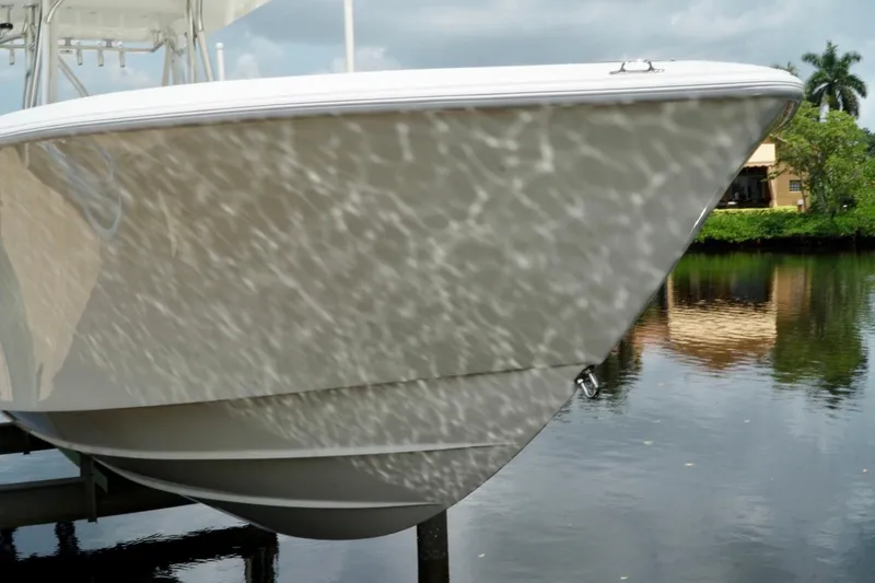  Yacht Photos Pics 2017 SeaVee 34Z boat reflecting water patterns, docked near lush greenery.