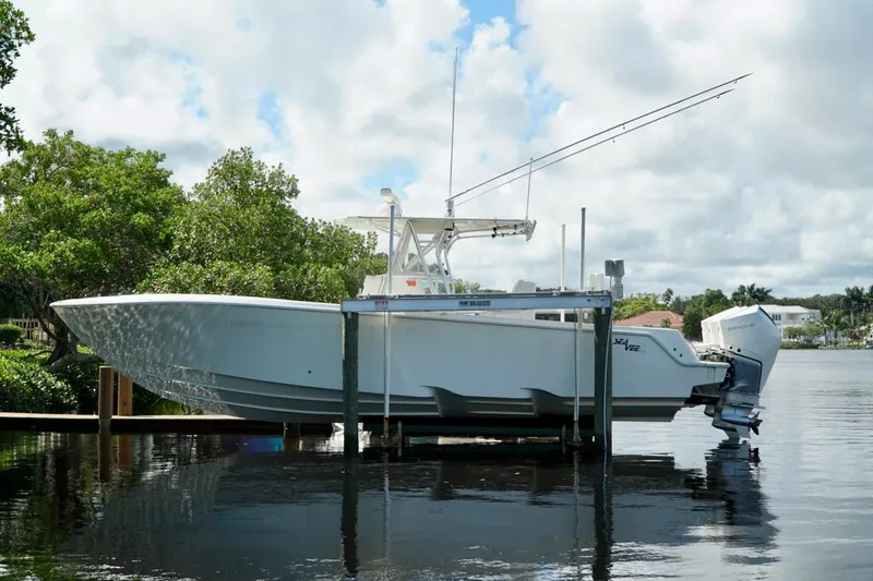 Yacht Photos Pics 2017 SeaVee 34Z boat on lift by waterfront, under cloudy sky.