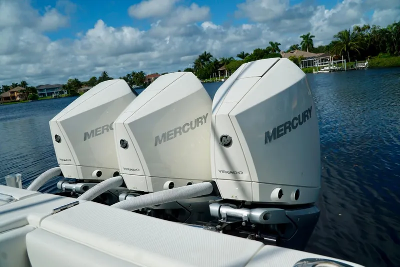  Yacht Photos Pics Triple Mercury Verado engines on a 2017 SeaVee 34Z boat, docked on a serene lake.