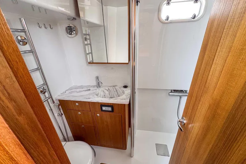  Yacht Photos Pics Luxurious bathroom in 2025 Targa 46 yacht with wood accents and marble countertop.