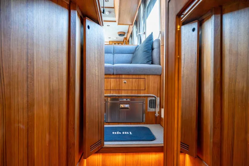  Yacht Photos Pics Luxurious interior of 2025 Targa 46 yacht with wooden finish and cozy seating area.