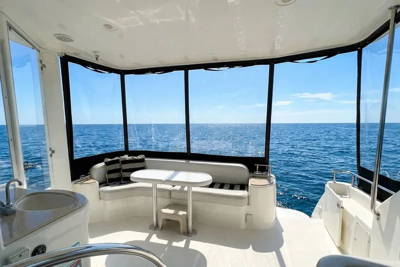 Jamm Yacht Photos Pics 2005 Meridian 459 Motoryacht interior with ocean view, featuring seating and table.