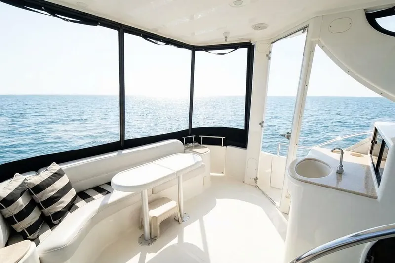 Jamm Yacht Photos Pics Luxurious 2005 Meridian 459 Motoryacht interior with ocean view, featuring seating and kitchenette.