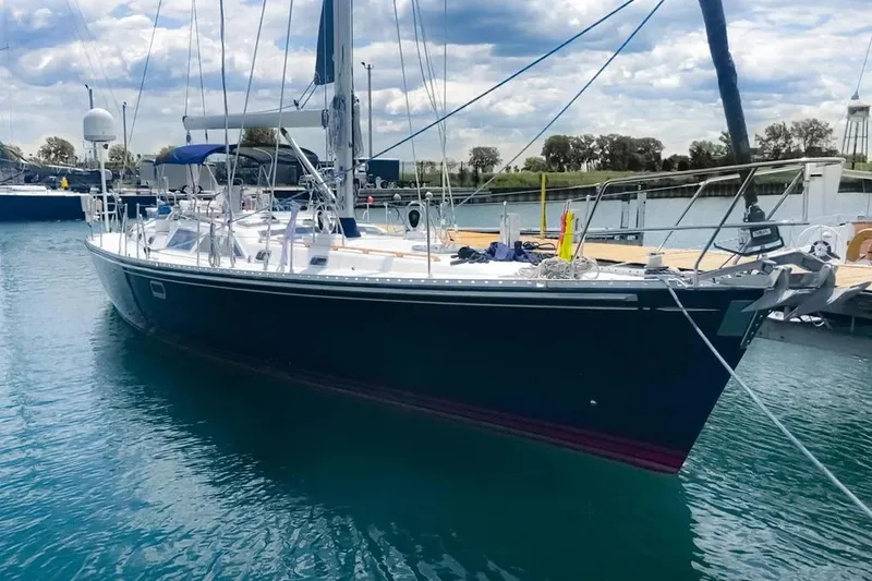 Violina Yacht Photos Pics Sailing yacht Hylas 54, 1999 model, docked in a marina under a cloudy sky.