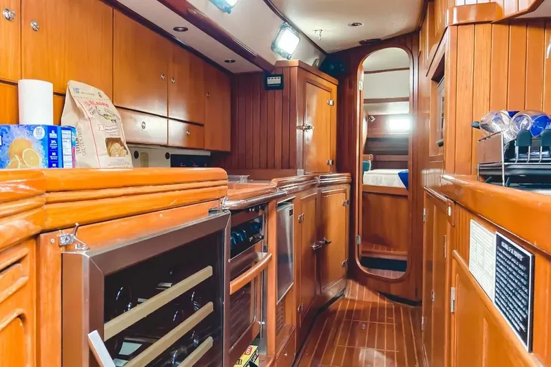 Violina Yacht Photos Pics Luxurious wooden interior of a 1999 Hylas 54 yacht kitchen with modern amenities.