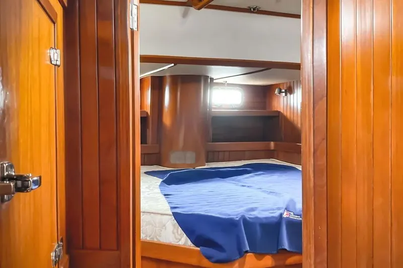 Violina Yacht Photos Pics Cozy cabin interior of 1999 Hylas 54 yacht with wooden paneling and bed.
