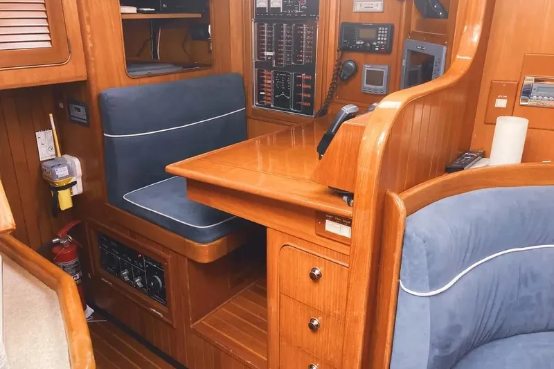 Violina Yacht Photos Pics Interior of a 1999 Hylas 54 yacht with wooden paneling and navigation equipment.