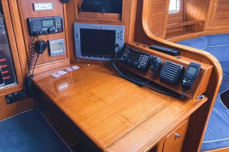 Violina Yacht Photos Pics Navigation station on a 1999 Hylas 54 yacht with communication equipment and wooden finish.