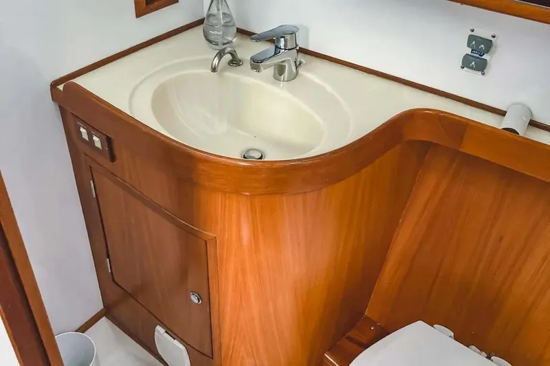 Violina Yacht Photos Pics Wooden bathroom interior on a 1999 Hylas 54 yacht, featuring a sink and cabinet.